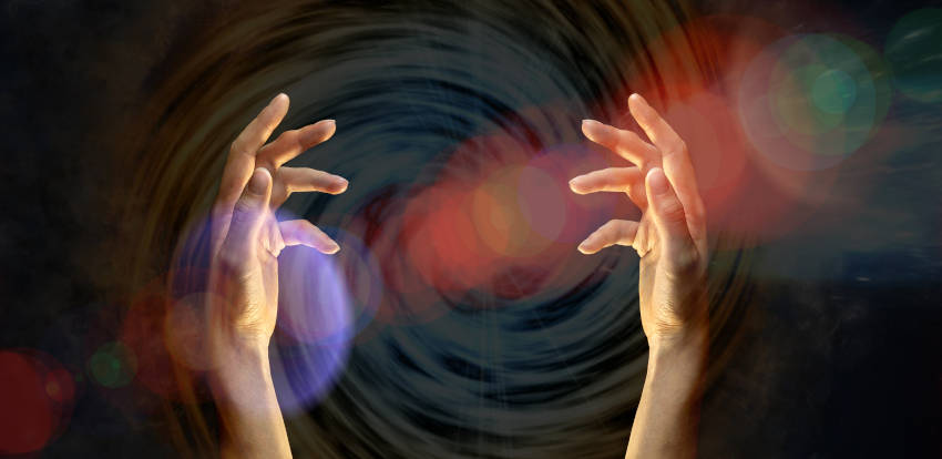 Hands, six inches apart, palms facing. A diagonal color changing orb from bottom left to top right.  A swirl staring in the center working its way out. The orbs and swirl represent energy. 